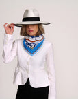 A model wearing a blue and white Safavid scarf, white jacket and wide brimmed white hat